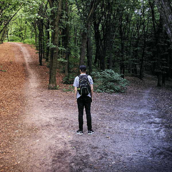 person standing at the crossroads of 2 paths